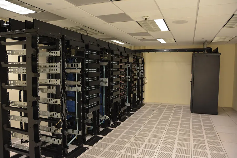 Rows of server racks with blinking lights in a data centre aisle.