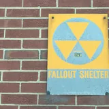 A yellow and black fallout shelter sign.